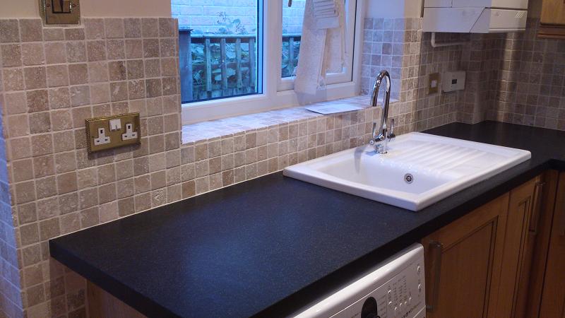 Dales Knotty Oak kitchen fitted with Encore worktops, travertine wall tiles and terracotta floor tiles