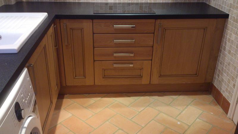 Dales Knotty Oak kitchen fitted with Encore worktops, travertine wall tiles and terracotta floor tiles