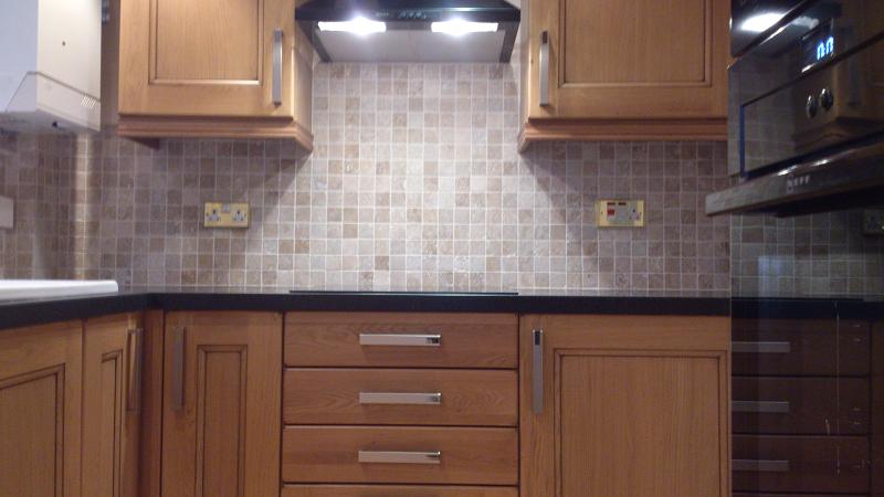 Dales Knotty Oak kitchen fitted with Encore worktops, travertine wall tiles and terracotta floor tiles