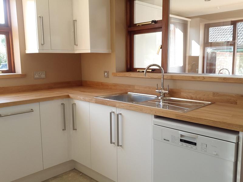 Logica White Gloss kitchen fitted with oak worktops