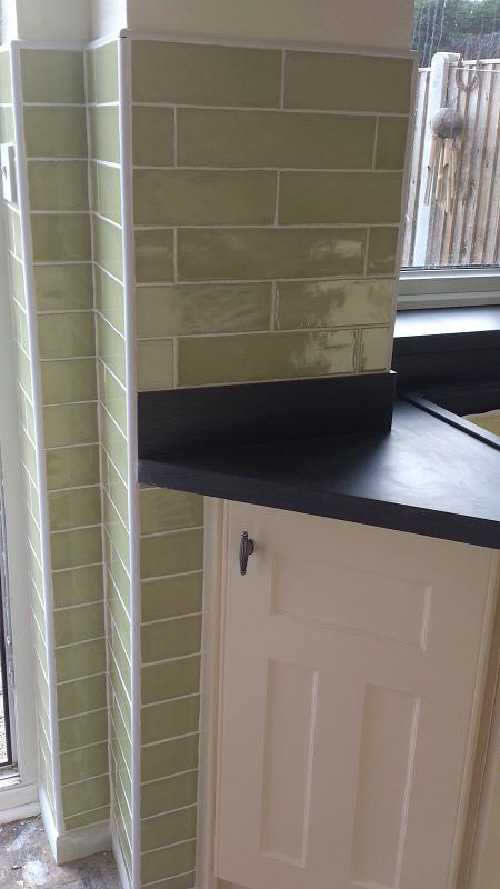 Optima T-bar Buttermilk kitchen fitted in Lowestoft with laminate worktops and pistachio wall tiles