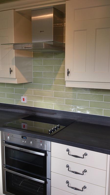 Optima T-bar Buttermilk kitchen fitted in Lowestoft with laminate worktops and pistachio wall tiles