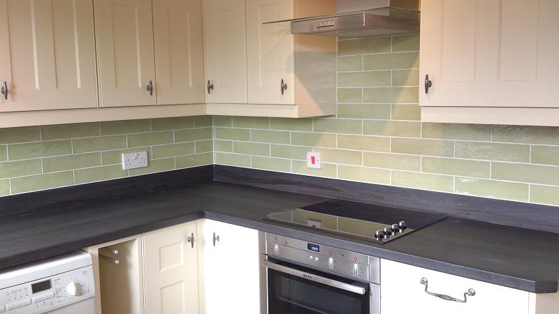 Optima T-bar Buttermilk kitchen fitted in Lowestoft with laminate worktops and pistachio wall tiles