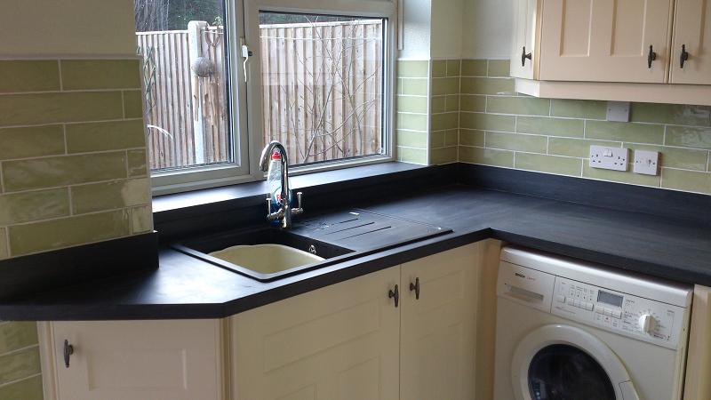 Optima T-bar Buttermilk kitchen fitted in Lowestoft with laminate worktops and pistachio wall tiles